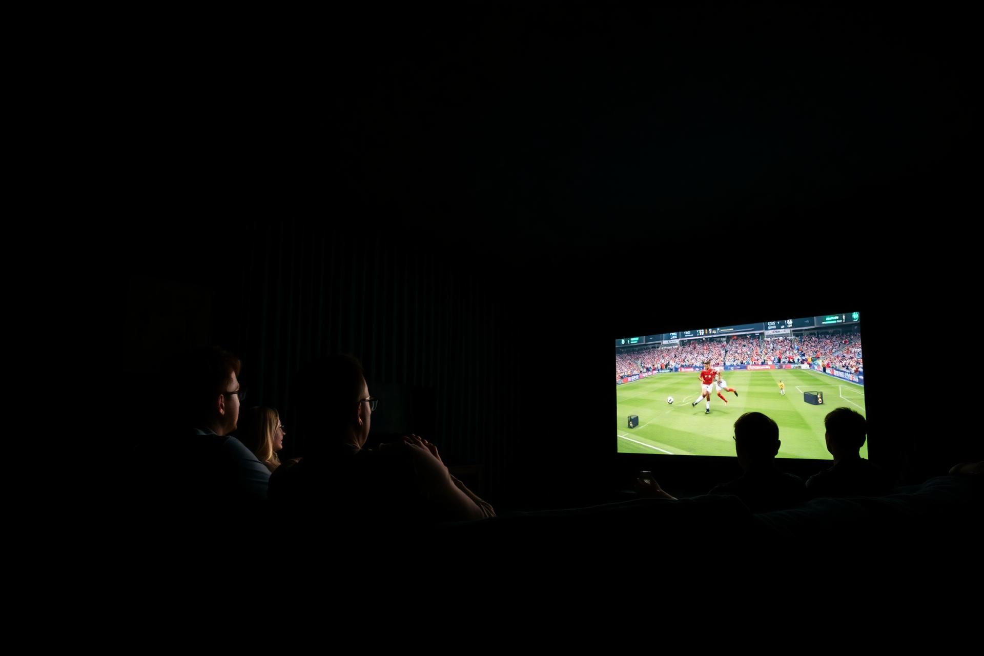 Amigos assistindo futebol em tela gigante